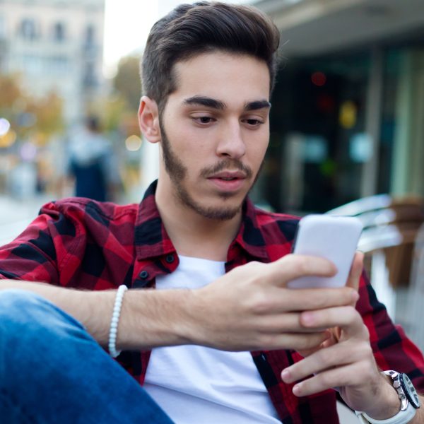 Young entrepreneur using his mobile phone at coffee shop.