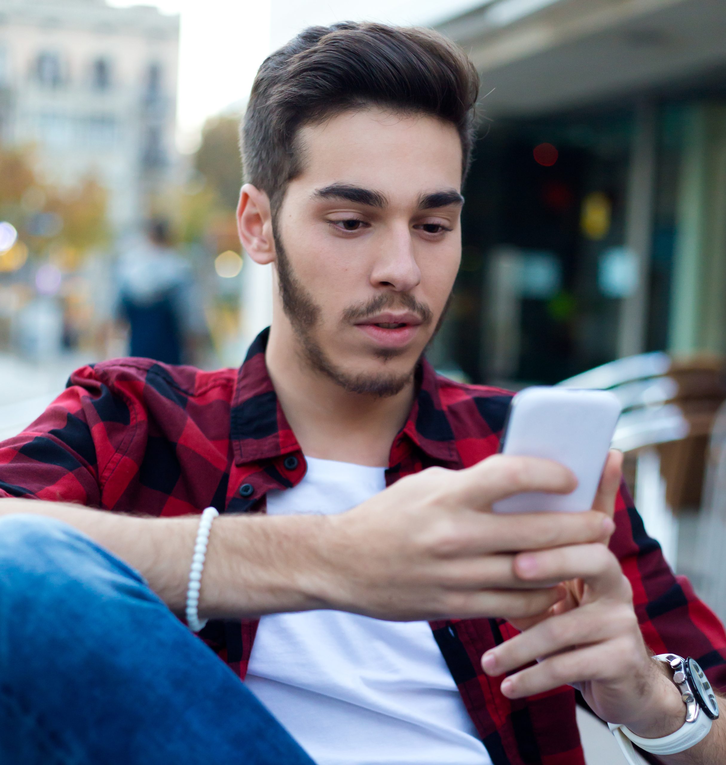 Young entrepreneur using his mobile phone at coffee shop.