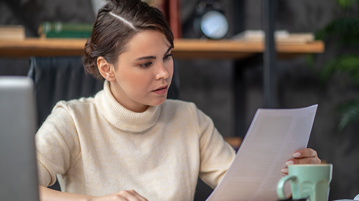 Concentrated lady examining documentation at the desk